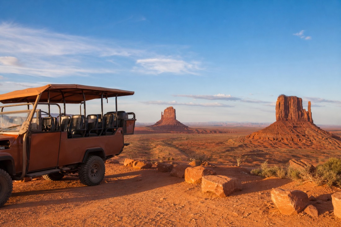 A guided open-air vehicle paused at a family-friendly overlook above the Mittens
