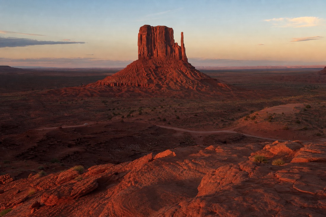Late golden-hour light washing over Merrick Butte from an overlook near the visitor center at day's end